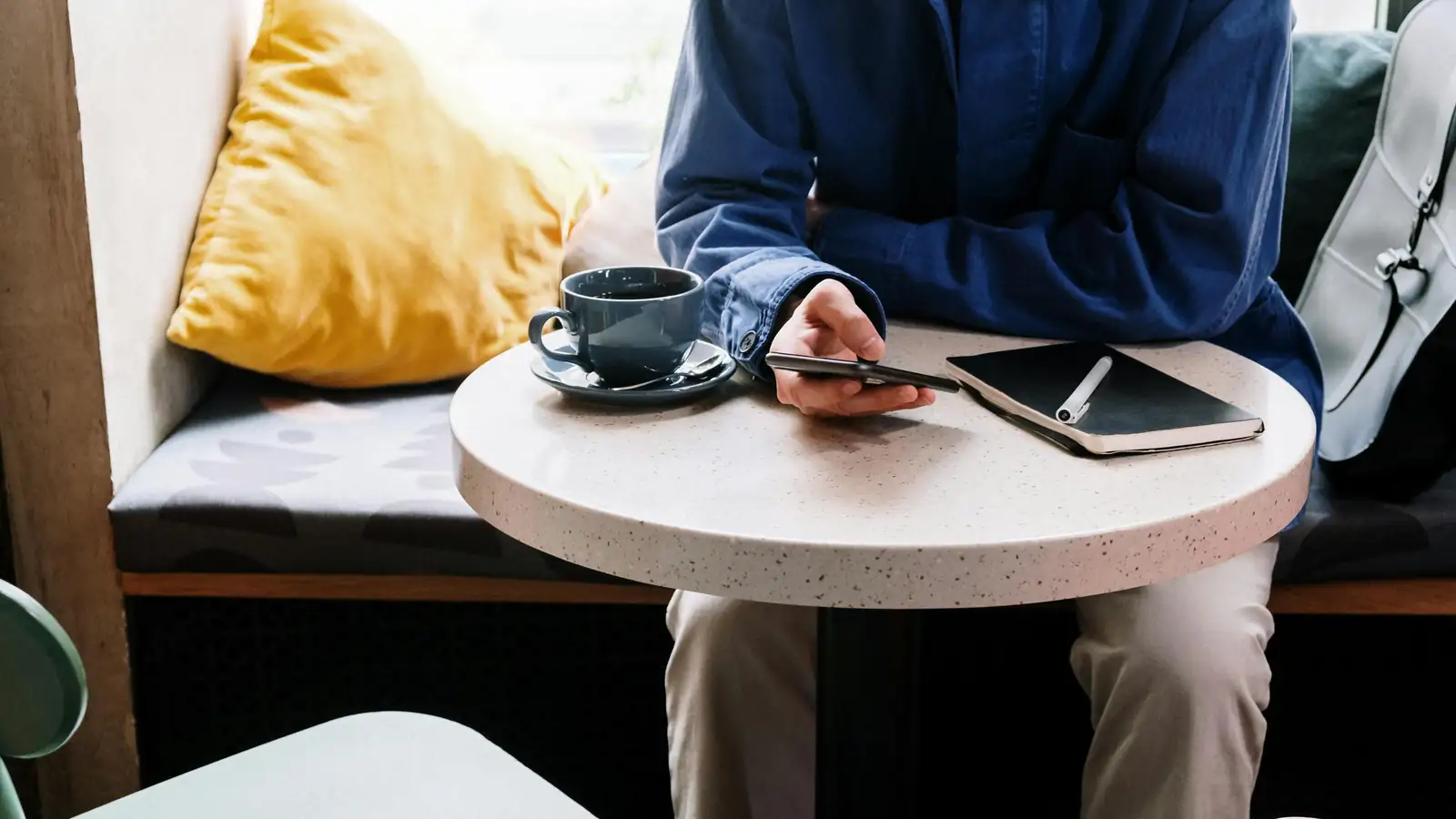 Person using language app on phone at a cafe