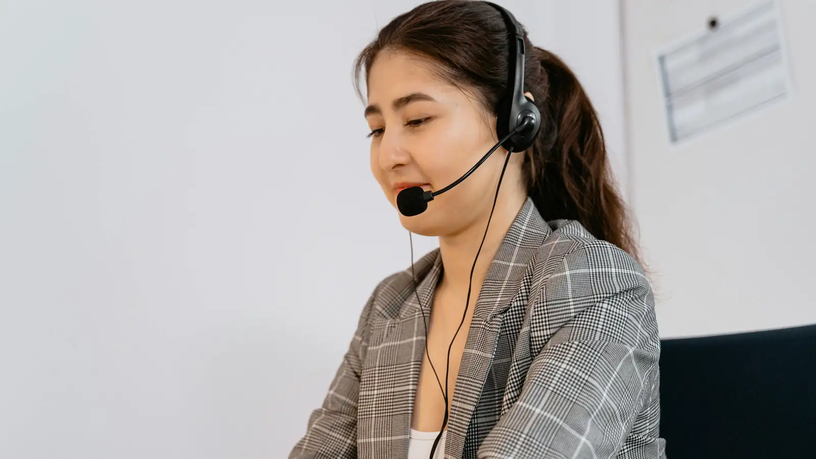 Customer support agent with headset at laptop